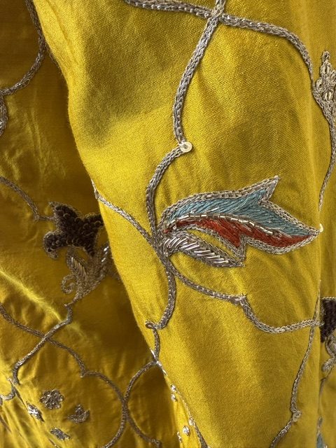 Close view of the ombré-dyed organza dupatta, yellow shading into sage with a gold border